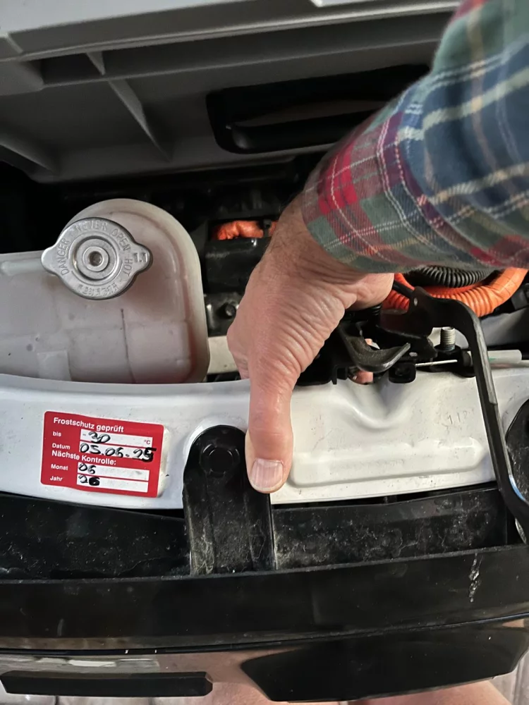 Notentriegelungsknopf für Ladekabel Dacia Spring, Handhaltung.webp